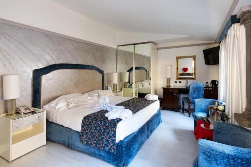 a bedroom with a large bed and blue chairs at Rivoli Boutique Hotel in Florence