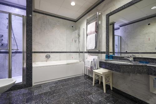 a bathroom with a tub and a sink and a bath tub at Rivoli Boutique Hotel in Florence