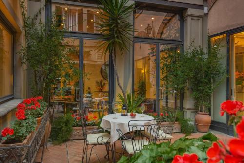 a patio with a table and chairs and flowers at Rivoli Boutique Hotel in Florence