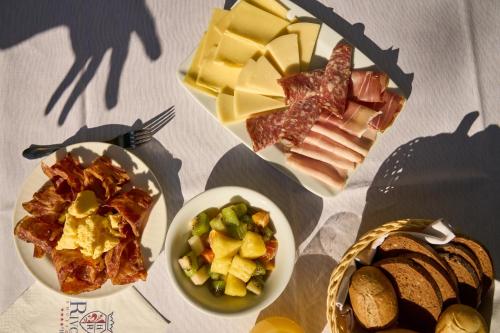 a table with three plates of food and a basket of bread at Rivoli Boutique Hotel in Florence