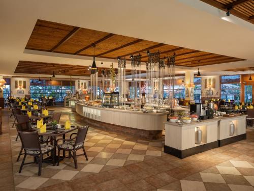 a restaurant with tables and chairs and a bar at Banyu Biru Villa in Lagoi