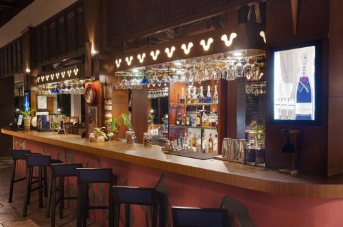a bar with bar stools and wine glasses at Banyu Biru Villa in Lagoi