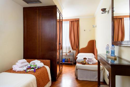 a small room with two beds and a chair at Grand Hotel Adriatico in Florence