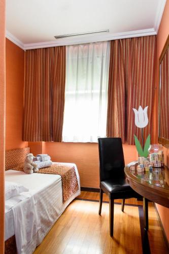 a bedroom with a bed and a table and a chair at Grand Hotel Adriatico in Florence