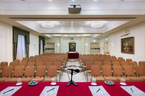 a conference room with chairs and a stage in the middle at Grand Hotel Adriatico in Florence