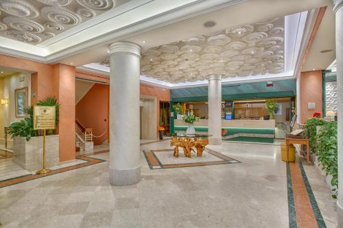 a lobby with columns and a table in a building at Grand Hotel Adriatico in Florence