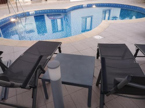 een paar stoelen en een zwembad bij The Serenity Bungalow in Anarita