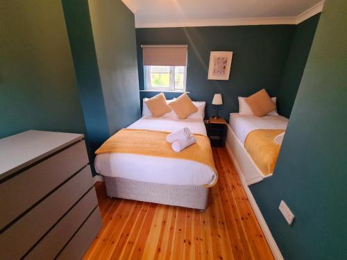 ゴールウェイにあるStylish 3 Bedroom Galway Houseの緑の壁の小さな部屋のベッド2台