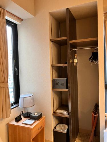 Habitación con armario, escritorio y estante. en ENT TERRACE AKIHABARA, en Tokio