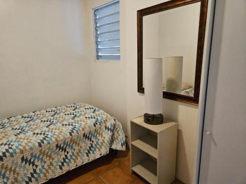 1 dormitorio con cama y espejo en Newly remodeled Economical 5BR, Third floor, en Mayagüez