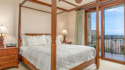 a bedroom with a canopy bed and a balcony at Ko Olina Beach Villas B701 in Kapolei