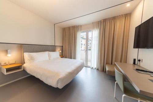 a hotel room with a bed and a desk at Open Hotel in Rimini