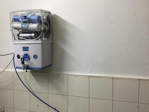 a washing machine on a wall in a bathroom at Chez Bussy in Puducherry