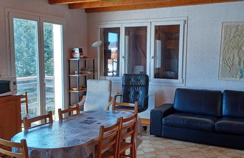 uma sala de estar com uma mesa e um sofá em Appartement Daniel em Lamoura