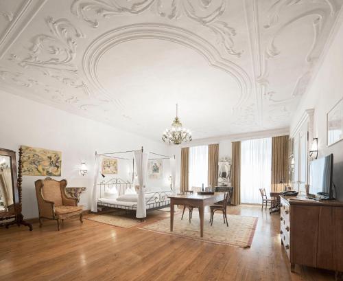 ein verziertes Wohnzimmer mit einem Tisch und einem Sofa in der Unterkunft Hotel Orphée - Großes Haus in Regensburg