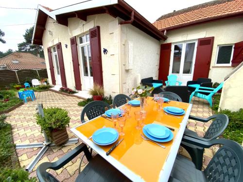 - une table avec des assiettes et des verres sur la terrasse dans l'établissement MAISON FLEURIE quartier calme, à Arcachon