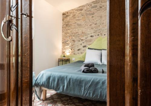 卡尔卡松L'atypique, La Vue et le Standing du 36 ! Emplacement, clim et extérieur !的一间卧室，配有一张床，墙是石的