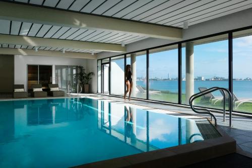 a woman standing in a swimming pool in a building at Helnan Marselis Hotel in Aarhus