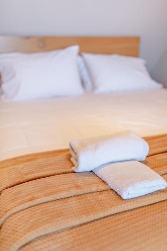 two white towels sitting on top of a bed at Zama Suites in Zakynthos Town