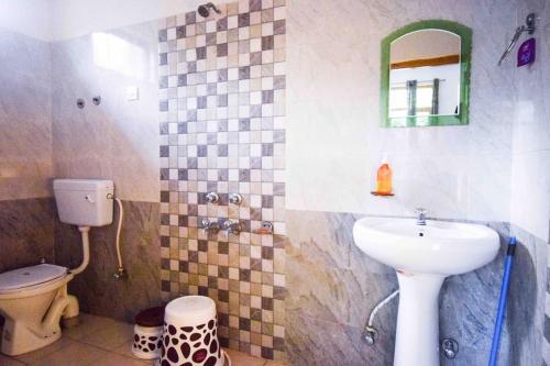 uma casa de banho com um lavatório, um WC e um espelho. em The VOID - Dharamkot em Dharamshala
