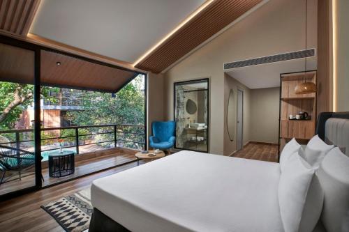 sypialnia z dużym łóżkiem i balkonem w obiekcie Avataara Resort & Spa w mieście Anjuna