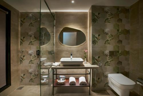 a bathroom with a sink and a toilet at Avataara Resort & Spa in Anjuna