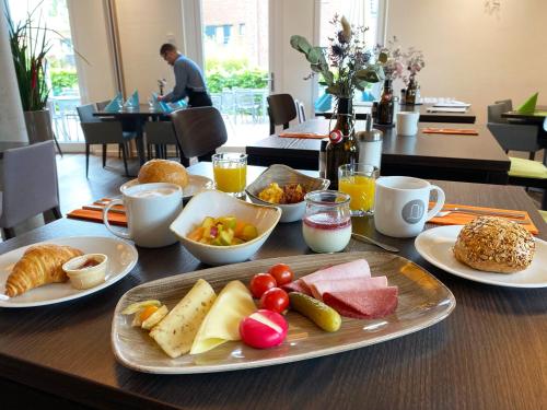 un tavolo con un piatto di cibo su un tavolo di Alexianer Hotel am Wasserturm a Münster