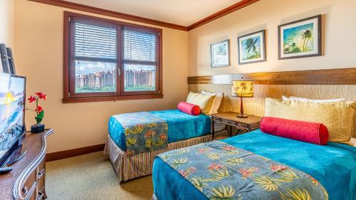 a hotel room with two beds and a television at Ko Olina Beach Villas B706 in Kapolei