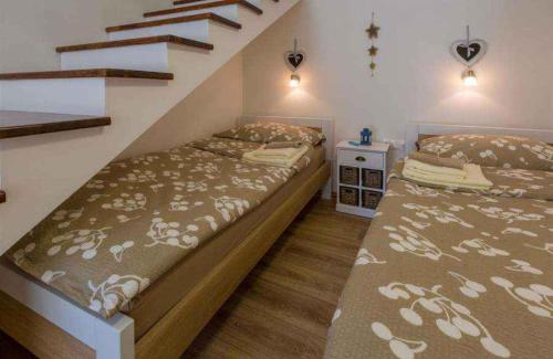 a bedroom with two beds and a staircase at Holiday home in Crikvenica 39225 in Crikvenica