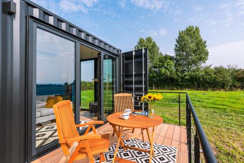 a tiny house with a table and chairs on a patio at the BOX BNB in Wilton