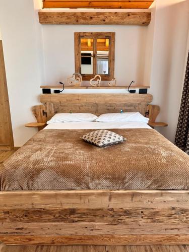 a bedroom with a wooden bed with a mirror at C’era una volta un Re… in Calalzo