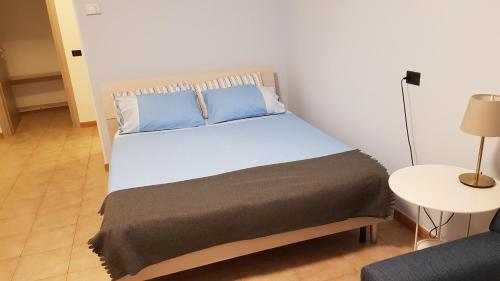 um quarto com uma cama grande e almofadas azuis em Mihousing-GM1, Ampio Monolocale nelle vicinanze di Milano e Monza em Carugate