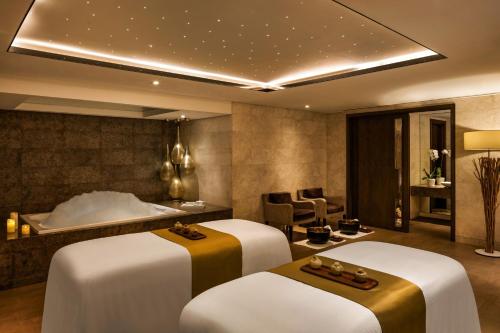 a spa room with three massage tables and a bed at Sheraton Grand Hotel, Dubai in Dubai