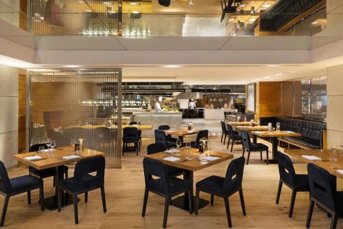 a restaurant with wooden tables and chairs and a bar at Sheraton Grand Hotel, Dubai in Dubai