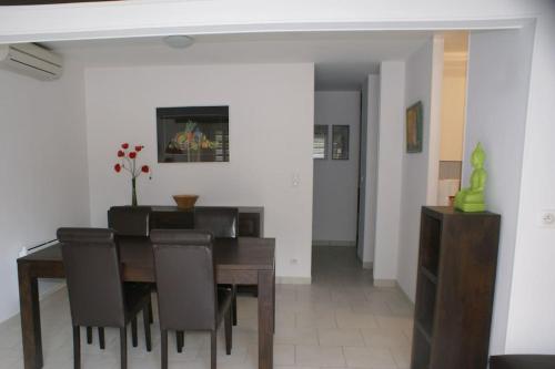 une salle à manger avec une table et des chaises en bois dans l'établissement Villa 68, port nature au village naturiste, au Cap d'Agde