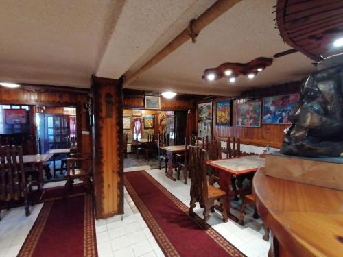 un restaurante con mesas de madera y sillas en una habitación en Семеен хотел Калина Family hotel Kalina Говедарци en Govedartsi