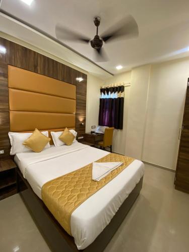 a bedroom with a large bed with a ceiling at Hotel Blue Wellington - Near Mumbai Airport in Mumbai