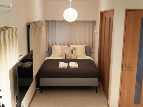 sypialnia z łóżkiem z dwoma ręcznikami w obiekcie Lido North Shinagawa w Tokio