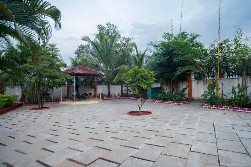 a courtyard of a house with trees and a pavilion at Karjat retreat 4bhk pvt farmhouse in Karjat