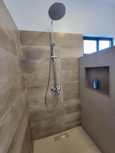 a shower with a shower head in a bathroom at Modern - Wan Pipel with Terrace in Paramaribo