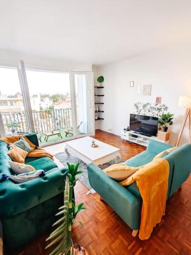 un salon avec deux canapés bleus et une table dans l'établissement Cosy Mirabelle 2CH - Parc Expo - Balcon & Parking, à Pau