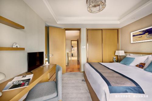 a hotel room with a bed and a television at Savills Residence Daxin Shenzhen Bay in Shenzhen