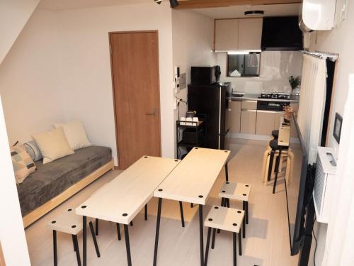mały apartament z dwoma stołami i kanapą w obiekcie Lido North Shinagawa w Tokio