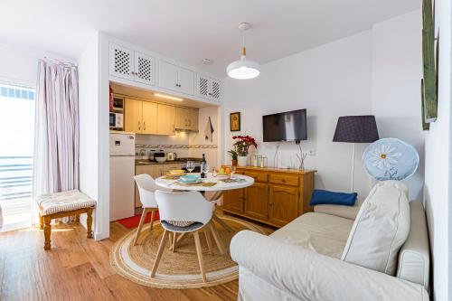 Una sala de estar y una cocina con mesa y sillas. en The Manga Beach Sea view Studio, Sandy beach & Crystal clear water, 5G Wifi & Airco, en La Manga del Mar Menor