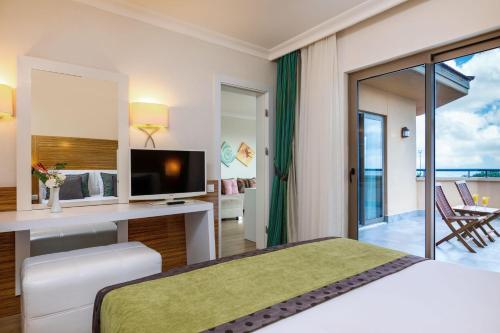 a bedroom with a bed and a desk with a television at Asteria Family Resort Belek in Belek