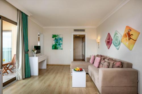 a living room with a couch and a table at Asteria Family Resort Belek in Belek