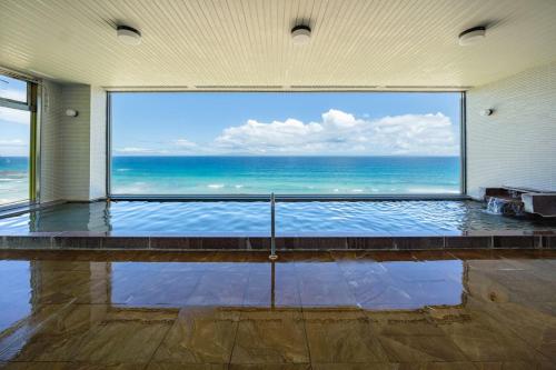 a large window in a room with a view of the ocean at Shimoda Prince Hotel in Shimoda