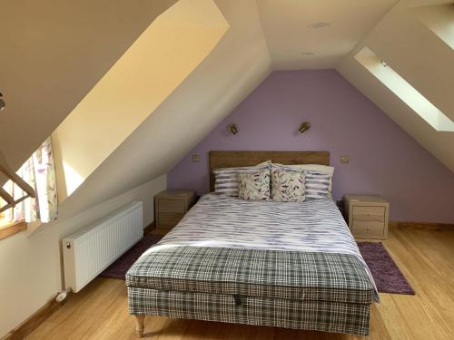 um quarto com uma cama num sótão em Locheil Apartment em Boat of Garten