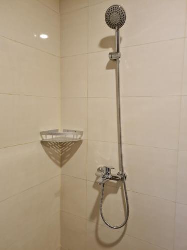 a shower with a shower head in a bathroom at 1 Bedroom Apartment nagoya thamrin city batam in Nagoya