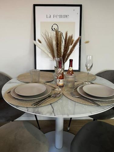 a table with plates and glasses and a bottle of wine at Charmante Penthouse - Therme Badewelt - Museum in Sinsheim Hoffenheim in Sinsheim